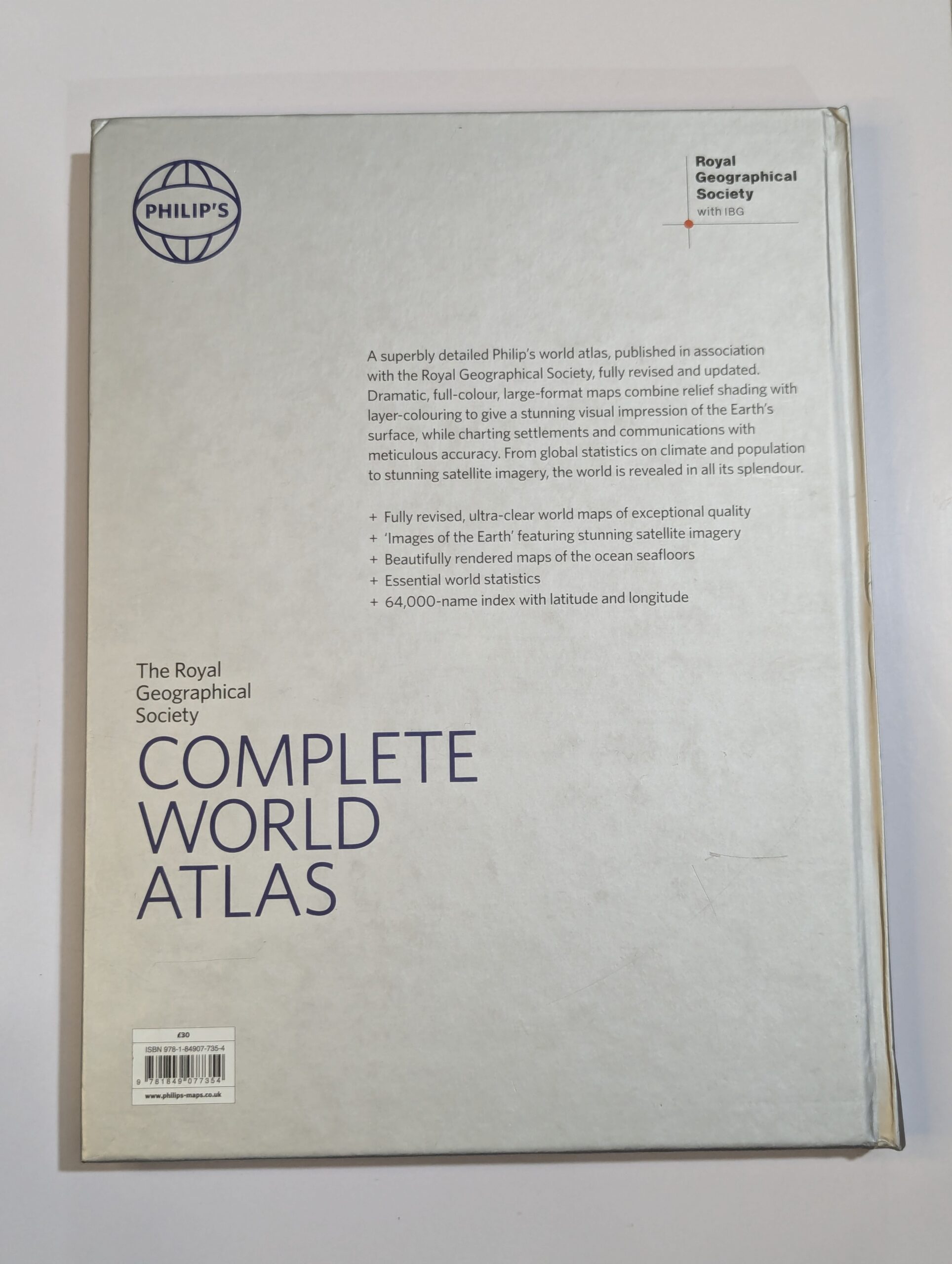 Inside spread from The Royal Geographical Society Complete World Atlas showing detailed world maps, satellite imagery, and geographical data